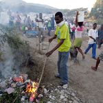 Yonel Regis, a pastor from a local church, burns trash at a refugee camp set up on a golf course in Port-au-Prince.